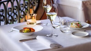 A table set for dining with a view of a lake and hills in the background. - Villa La Massa (Bagno a Ripoli)