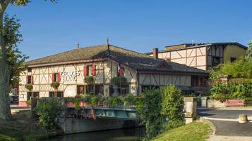 Un edificio tradicional con un cartel que dice "GEORGES BLANG" y un puente en primer plano.