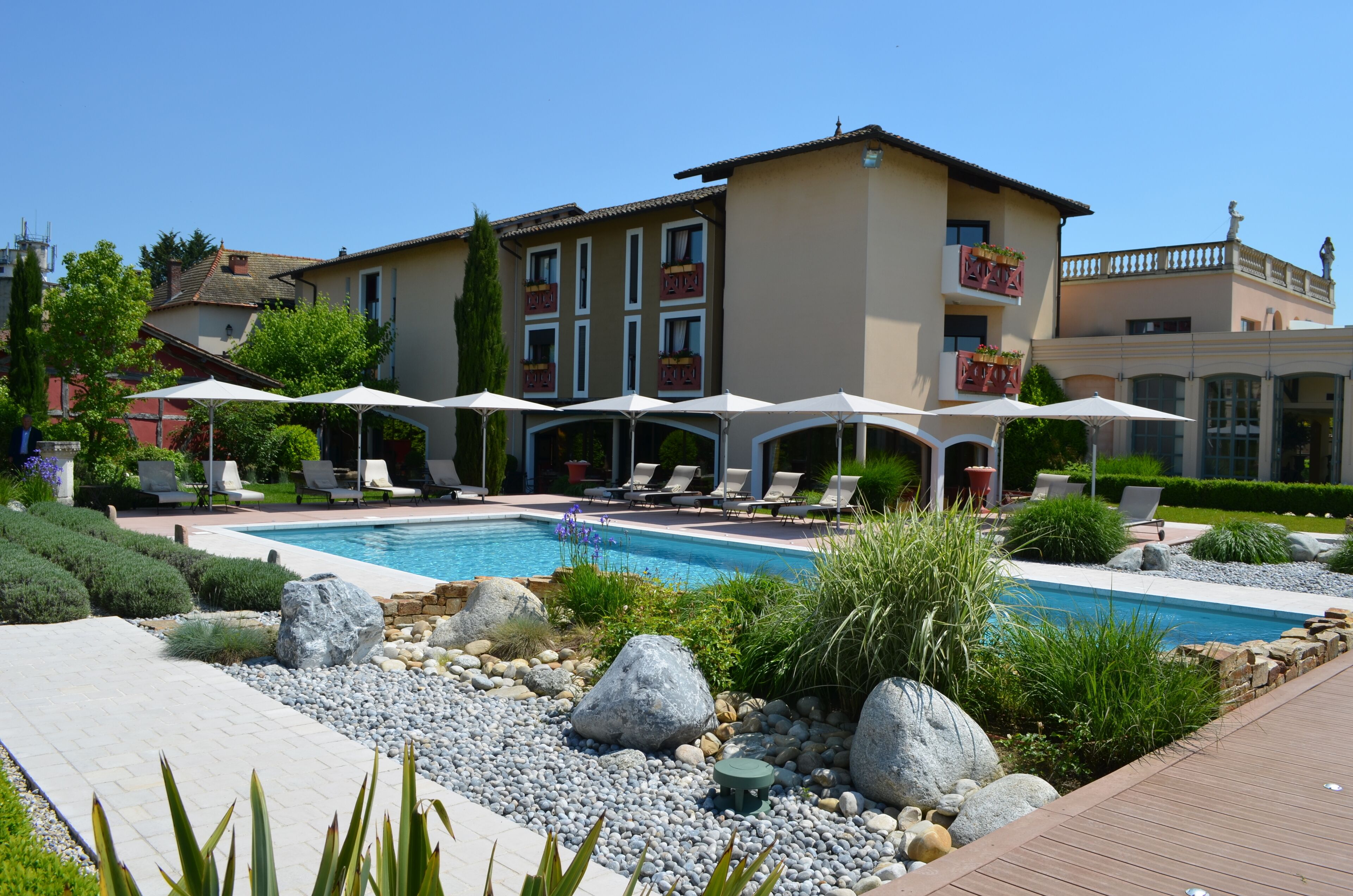 Un hôtel doté d’une piscine, d’un espace extérieur aménagé et d’un jardin bien entretenu.