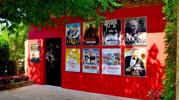 A red building with multiple movie posters on the wall.