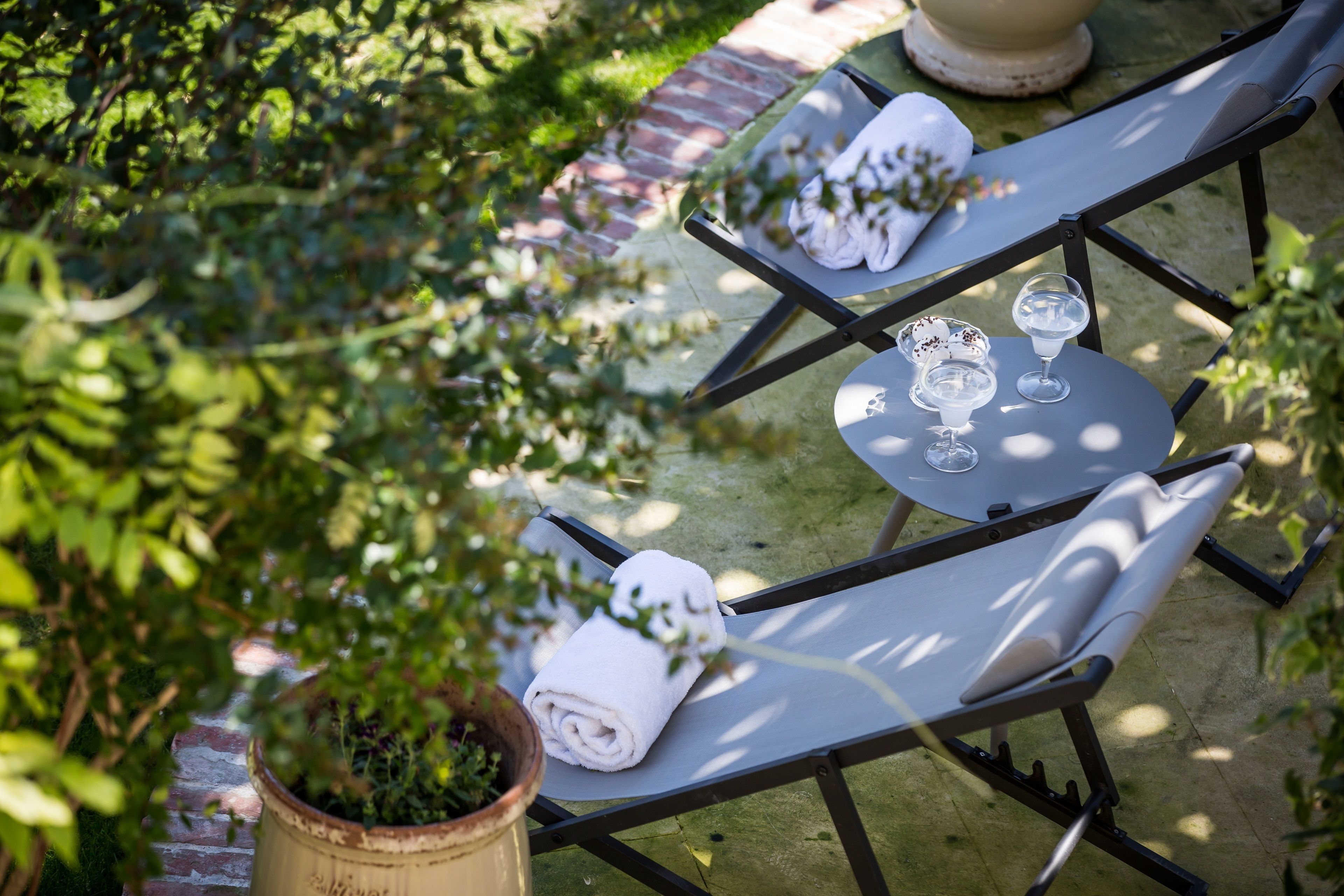Eine Terrasse mit zwei Tischen, auf jedem Tisch ein Handtuch und ein Glas.