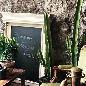A chalkboard with a welcome message, cacti, and a rustic chair. - Château de Trigance (Trigance)