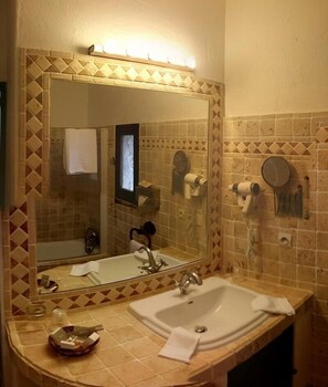 A bathroom with a large mirror, a sink, and a towel rack. - Château de Trigance (Trigance)