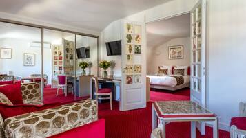 Una habitación de hotel compacta con cama, escritorio, silla y una mesita.