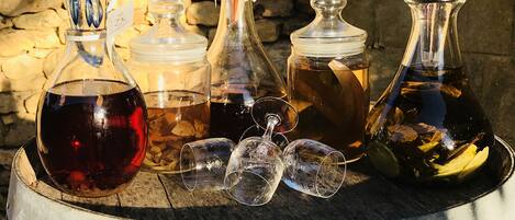 A wooden barrel with various glass containers and empty wine glasses on top.