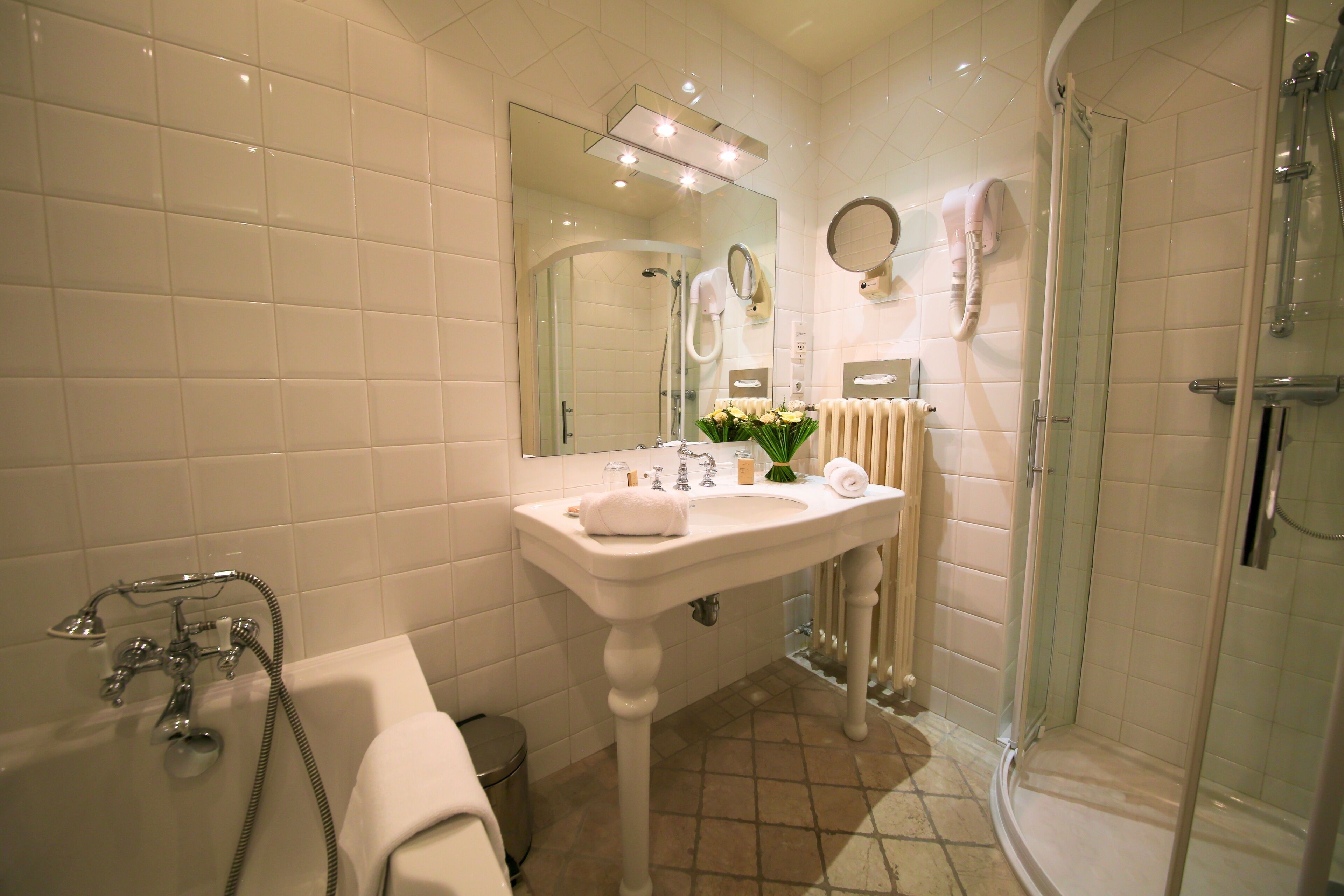 A bathroom with a bathtub, a sink, a mirror, and a shower.