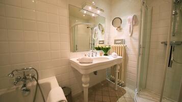 Une salle de bain avec une baignoire, un lavabo, un miroir et une douche.