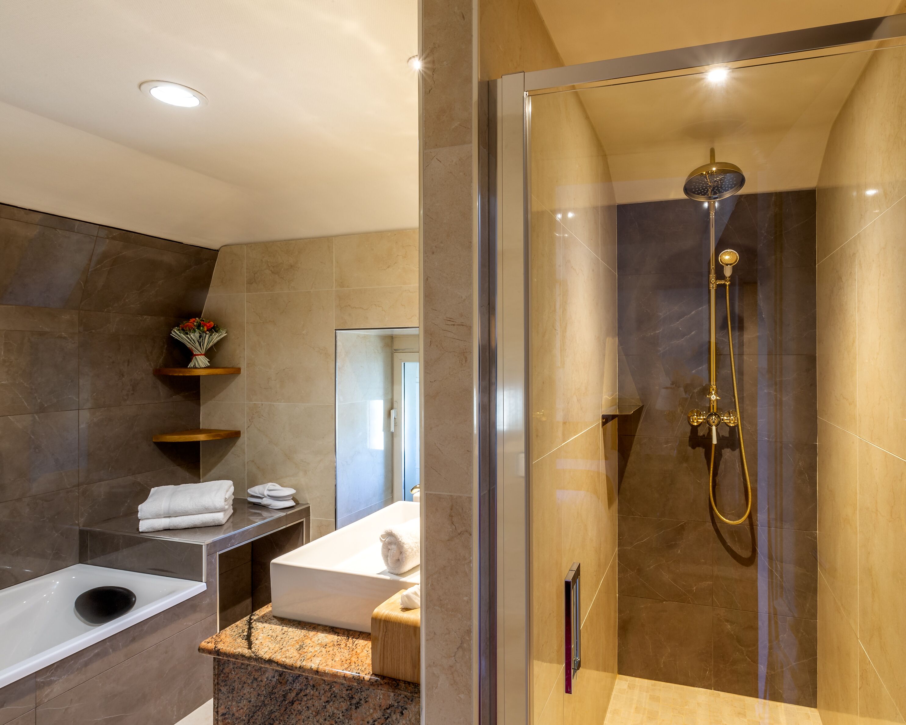 A modern bathroom with a glass-enclosed shower, a marble-tiled vanity, and a built-in toilet.