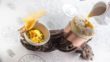 Una tavola apparecchiata con una ciotola di insalata di frutta e una tazza di caffè.
