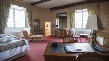 Une chambre d’hôtel comprenant un lit, un bureau, une chaise, une commode et un miroir.