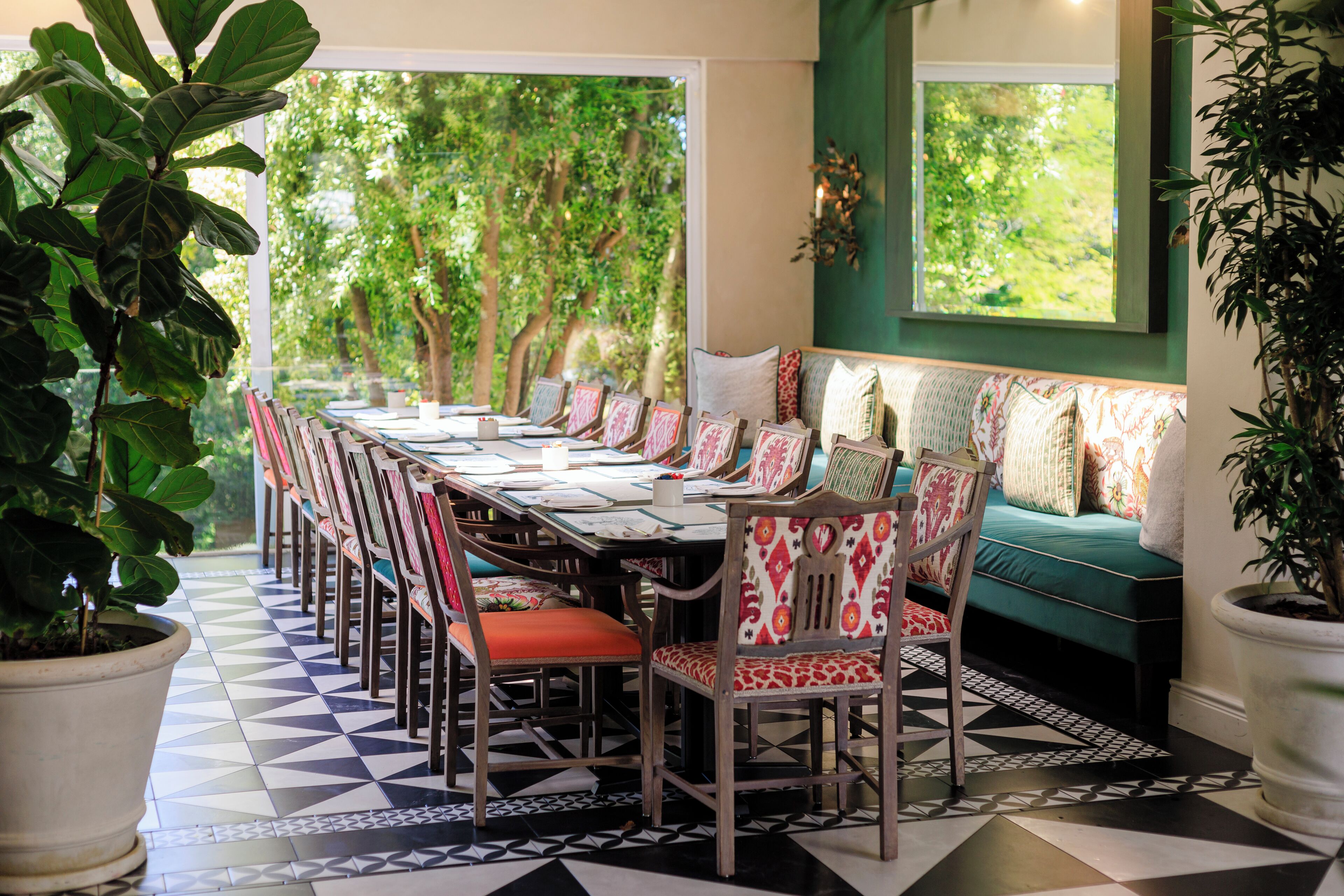 A dining area with a long table, chairs, and a bench with cushions.