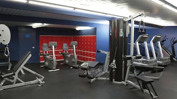 A gym with various exercise equipment including treadmills, weight machines, and free weights.
