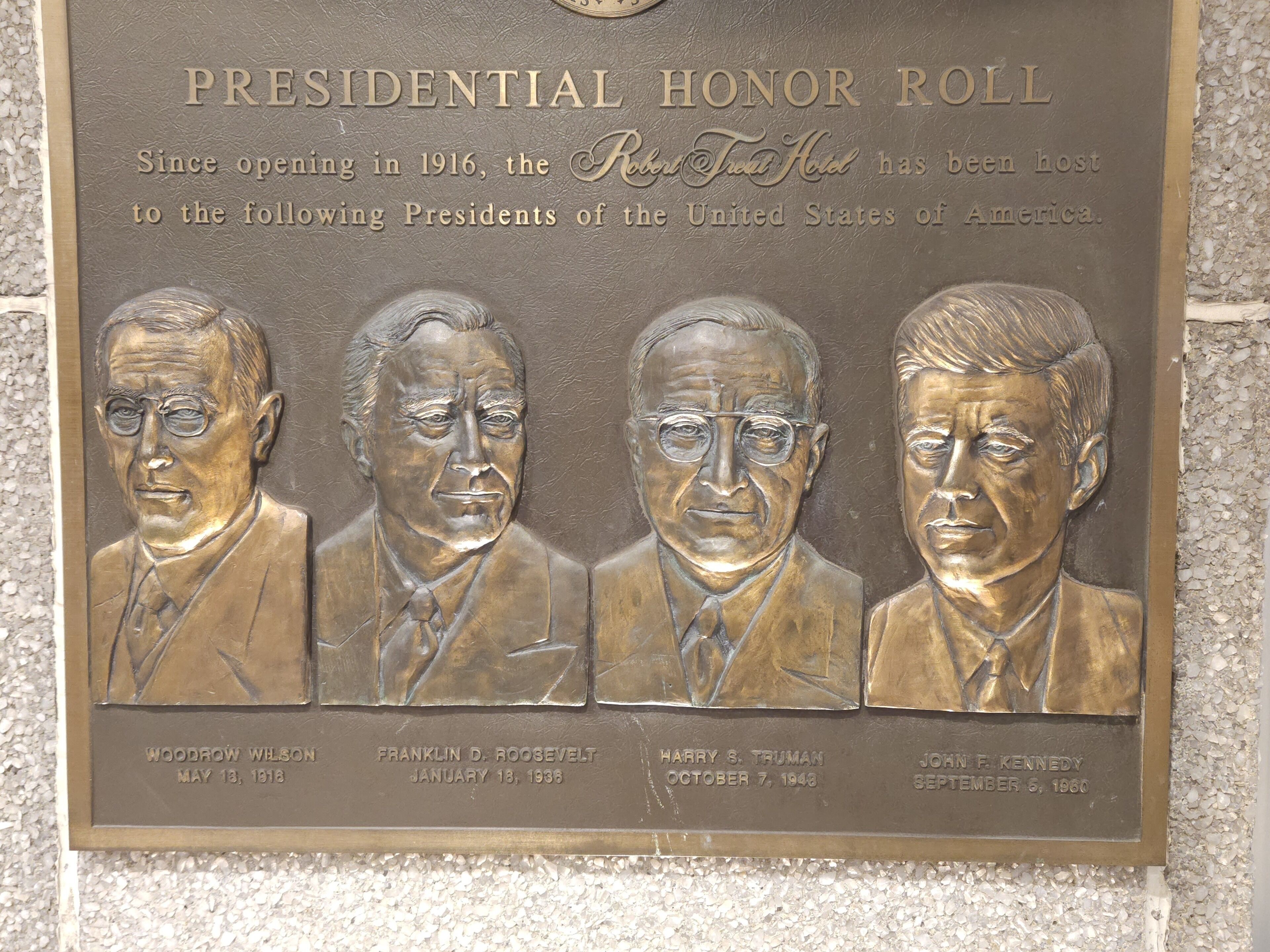 Eine bronzene Gedenktafel mit der Aufschrift "Presidential Honor Roll" und Porträts von vier US-Präsidenten.