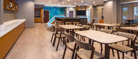 A modern hotel lobby with a reception desk, seating area, and a children's play area.