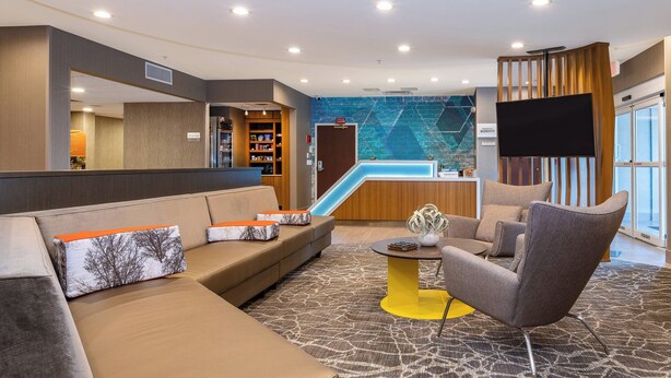 A modern lobby with a reception desk, seating area, and a large screen. - Springhill Suites By Marriott Orlando Altamonte Springs (Altamonte Springs)