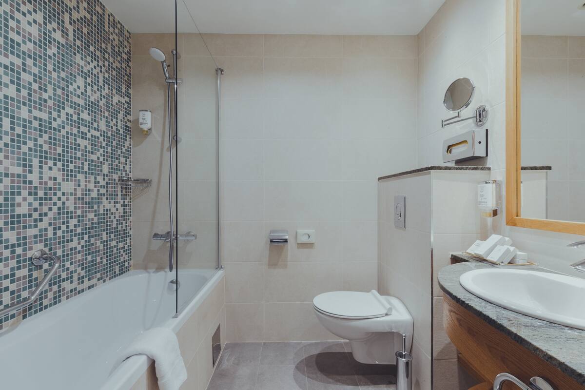 A modern bathroom with a bathtub, toilet, and sink.