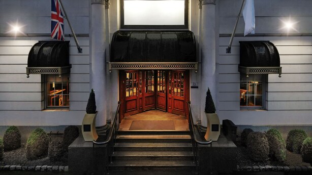 A grand entrance with a central staircase, ornate columns, and a large illuminated sign above. - Delta Hotels by Marriott Birmingham (Birmingham)