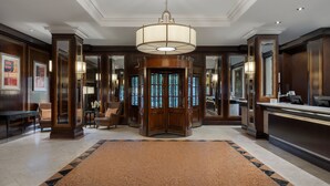 A lobby with a central revolving door, a reception desk, and a patterned carpet. - Delta Hotels by Marriott Birmingham (Birmingham)