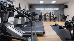 A gym with multiple treadmills, weight machines, and a large mirror. - Delta Hotels by Marriott Birmingham (Birmingham)