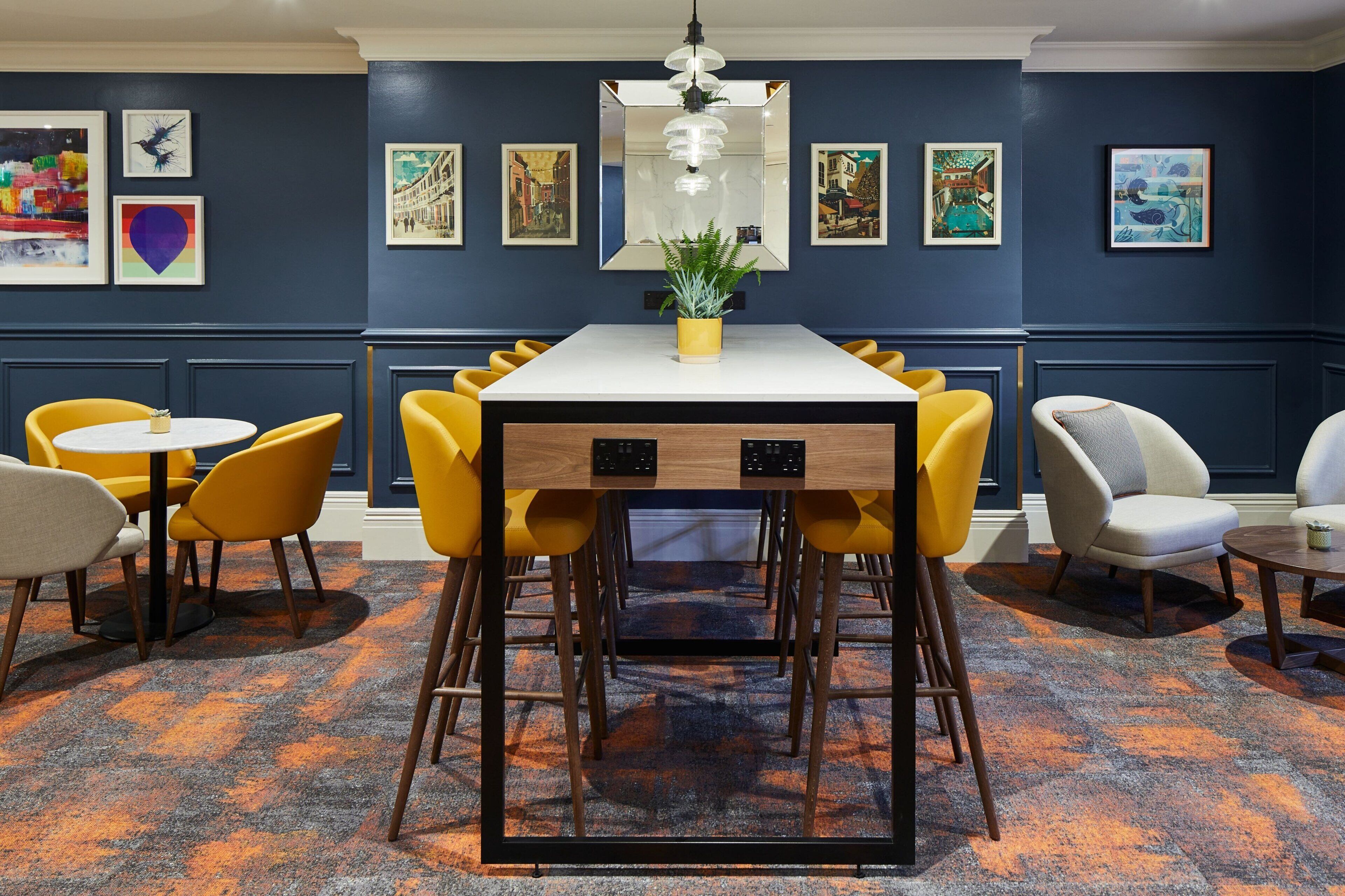 A dining area with a white table, yellow chairs, and a potted plant.