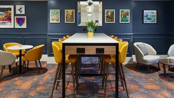 A dining area with a white table, yellow chairs, and a potted plant.