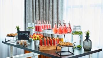 Une table de buffet proposant une variété d’aliments et de boissons, notamment des smoothies et des fruits, ainsi qu’un panneau indiquant « Aliments pour le cerveau ».