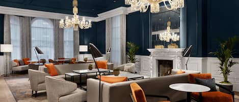 A luxurious lobby with a grand chandelier, plush seating, and a fireplace.