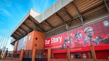 A stadium with a prominent advertisement for 'Our Story' and a visible entrance gate.