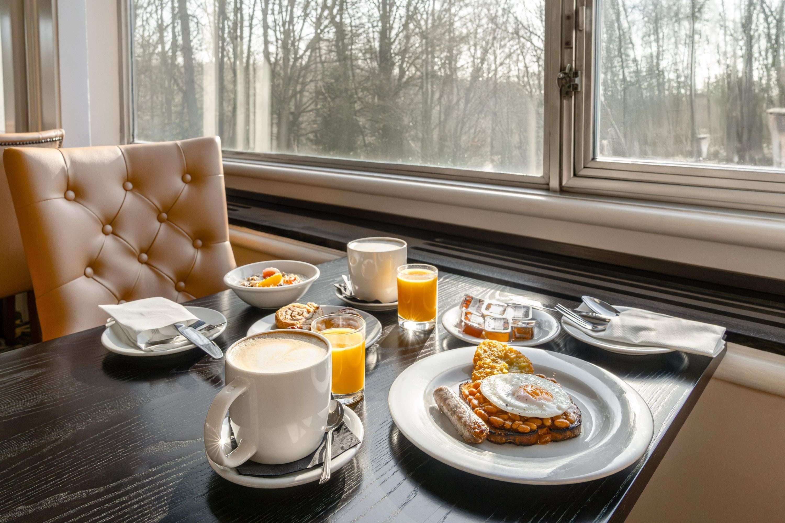 A breakfast setting with a table, chairs, and a window view.