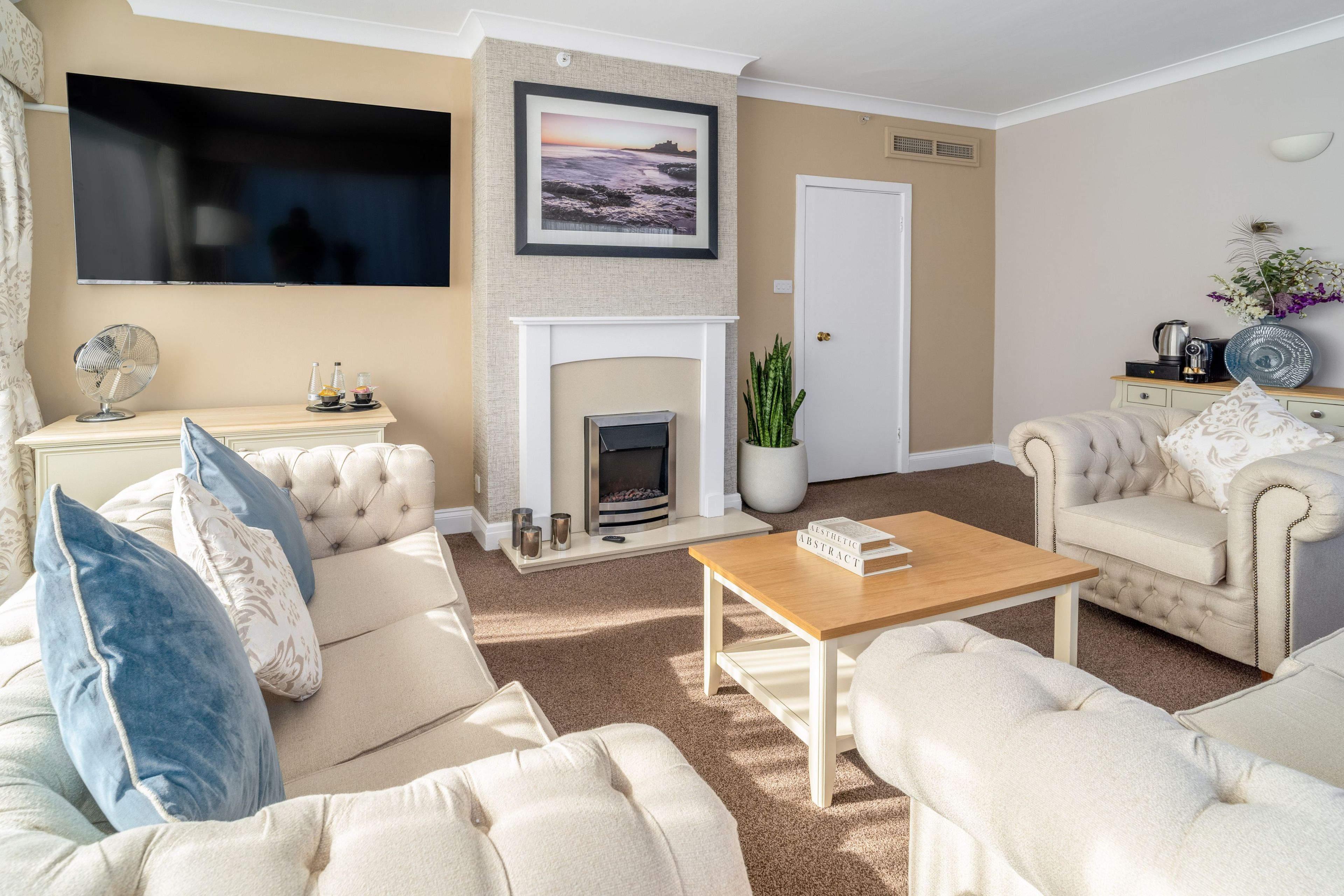A living room with a fireplace, a television, and a coffee table.
