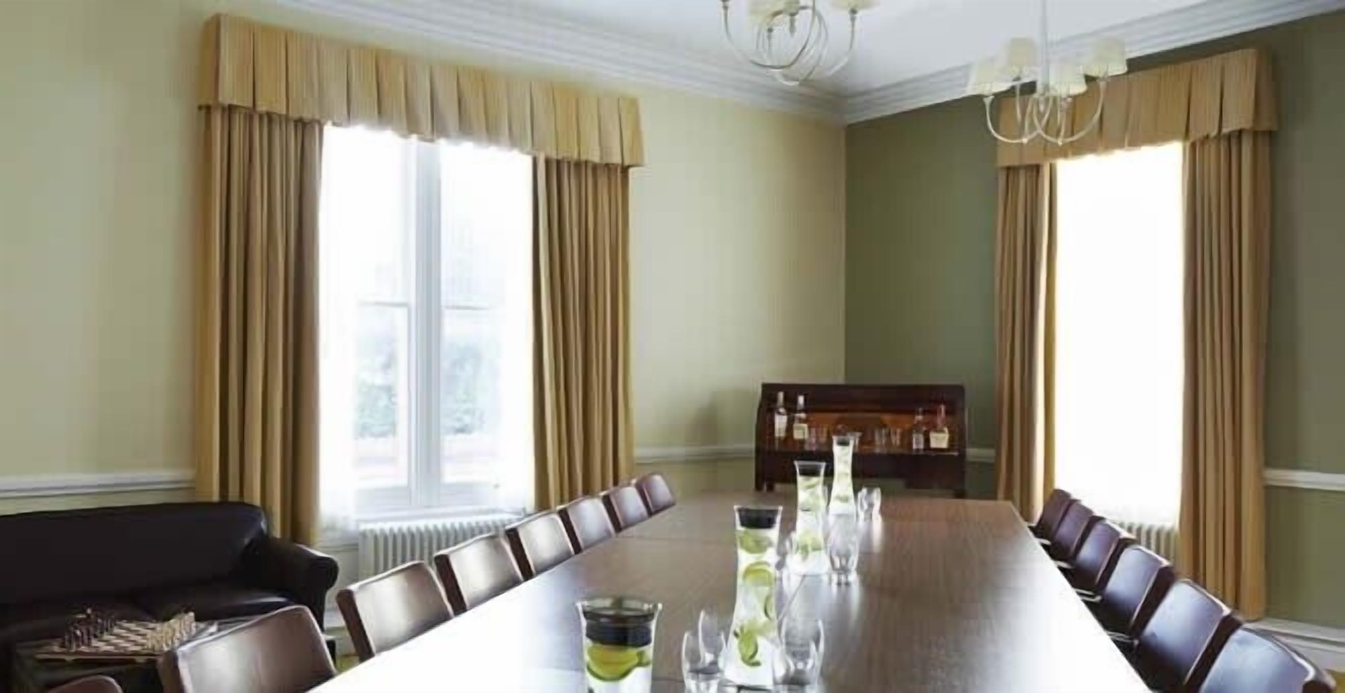 Une salle de conférence avec une longue table, des chaises et un canapé.