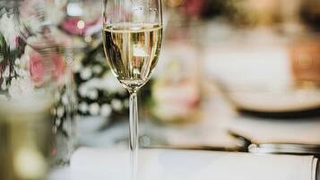 A table set for a formal dining occasion with a glass of white wine, cutlery, and a plate.