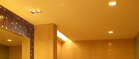 A bathroom with a large bathtub, a sink with a mirror, and a wooden vanity.