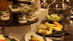 A buffet with various dishes and a salad bar.