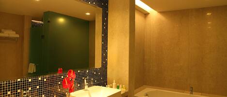 Un baño moderno con un espejo grande, dos lavamanos, una bañera y un salpicadero de azulejos.