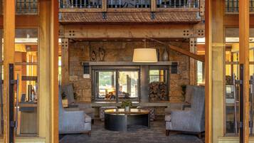 A spacious lobby with a stone wall, a fireplace, and a view of the outdoors.