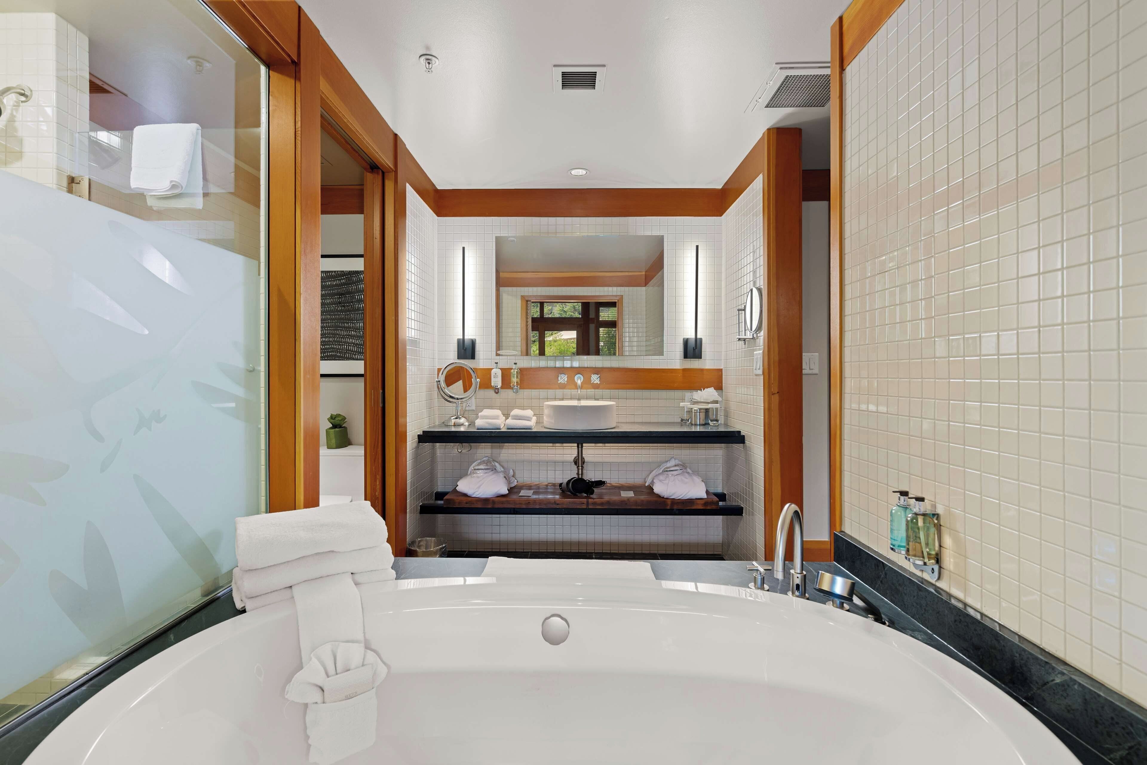 A modern bathroom with a freestanding bathtub, a vanity with a mirror, and a sink.