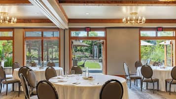 A dining area with round tables, chairs, and exit signs.