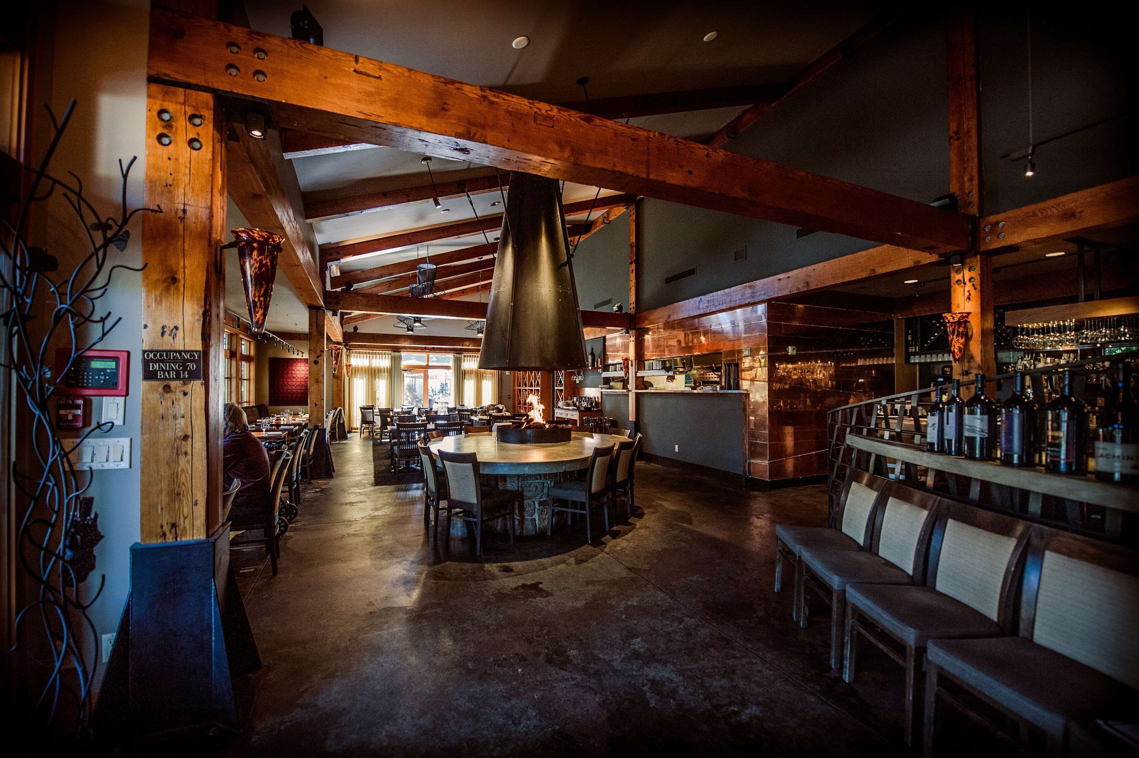A restaurant interior with wooden beams, a bar area, and a dining section.