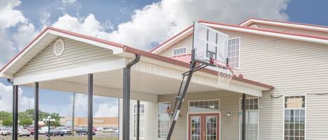 Un edificio con ingresso coperto, canestro da basket e insegna Walmart.