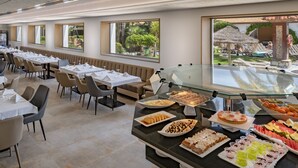 A buffet area with various food items and a view of an outdoor pool area. - 4R Gran Europe (El Vendrell)
