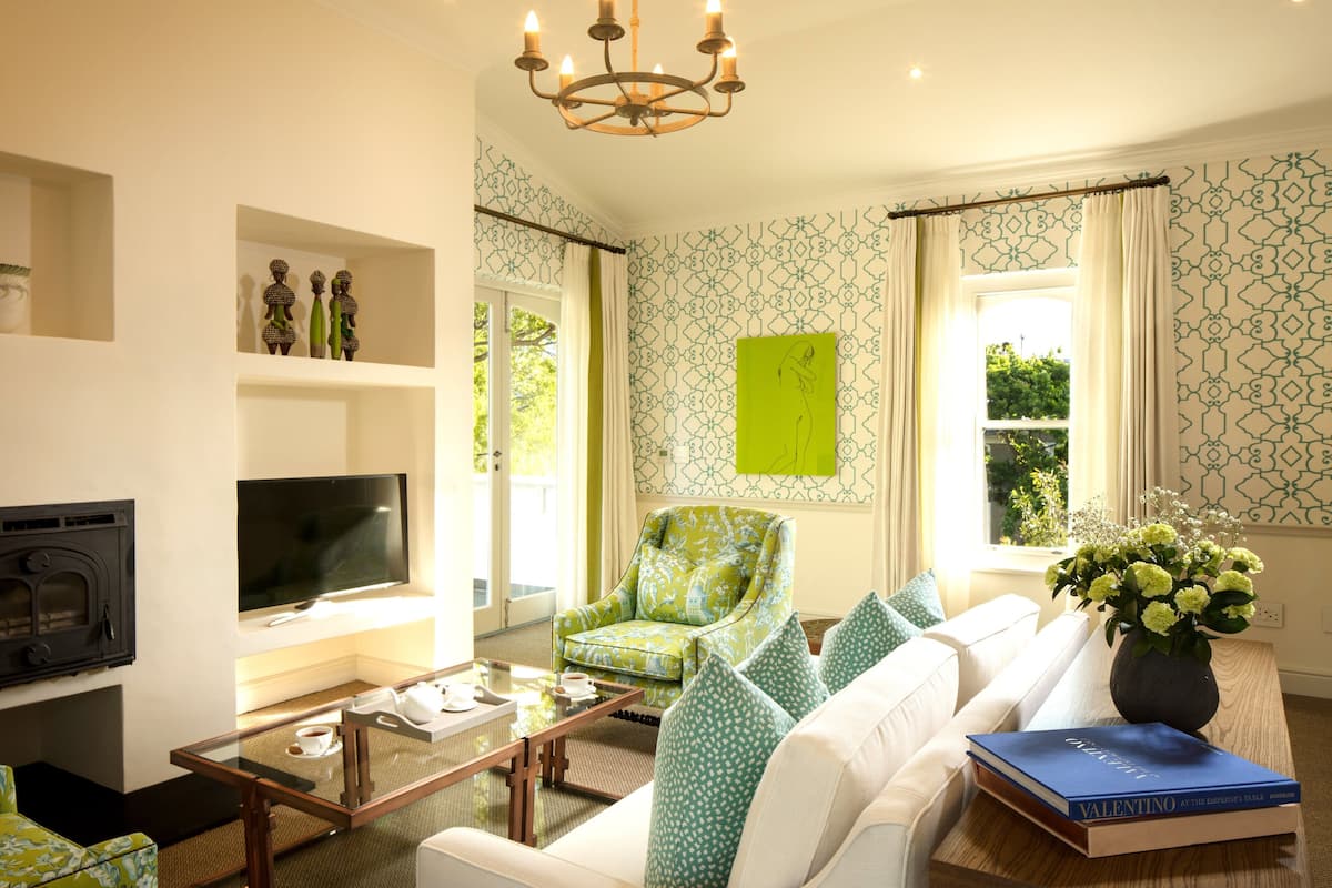Un salon comprenant un canapé, un fauteuil, une table basse, un téléviseur et des objets de décoration.