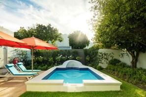 Piscine extérieure, parasols de plage, chaises longues