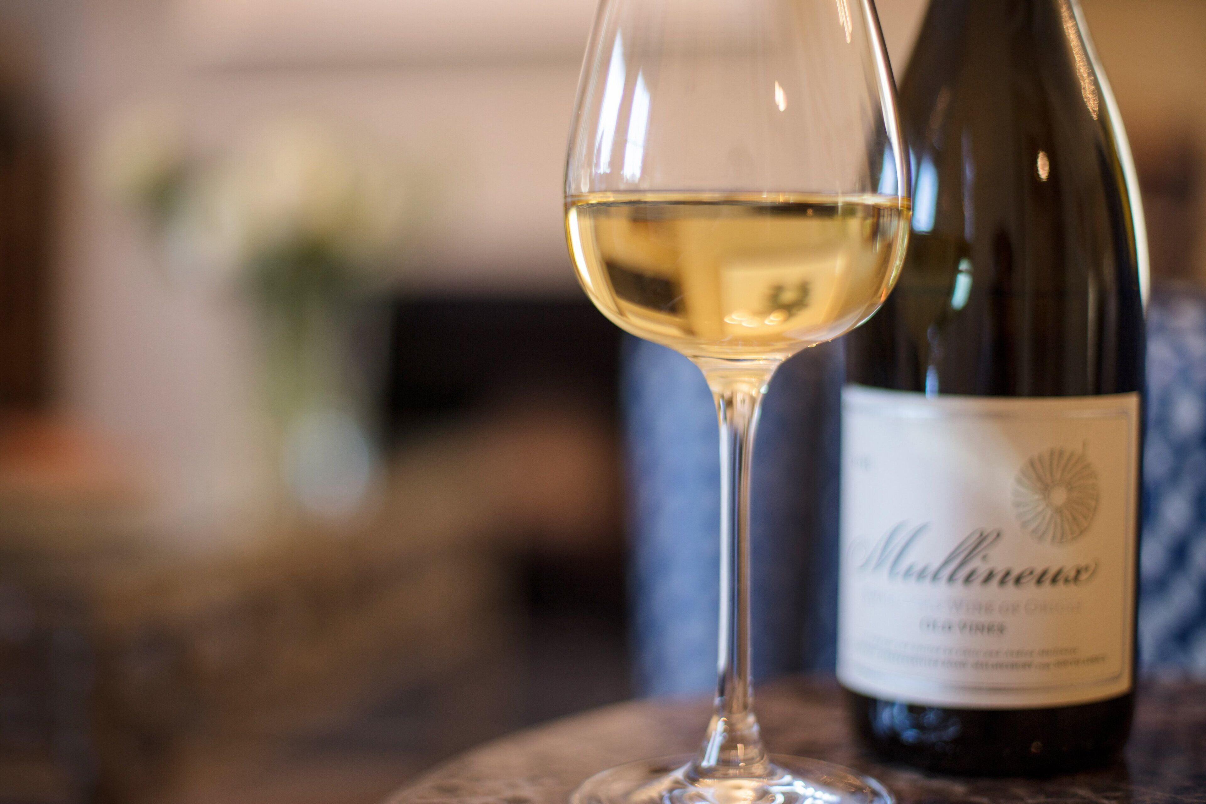 A wine glass with a bottle of wine labeled "Mullineux" next to it.