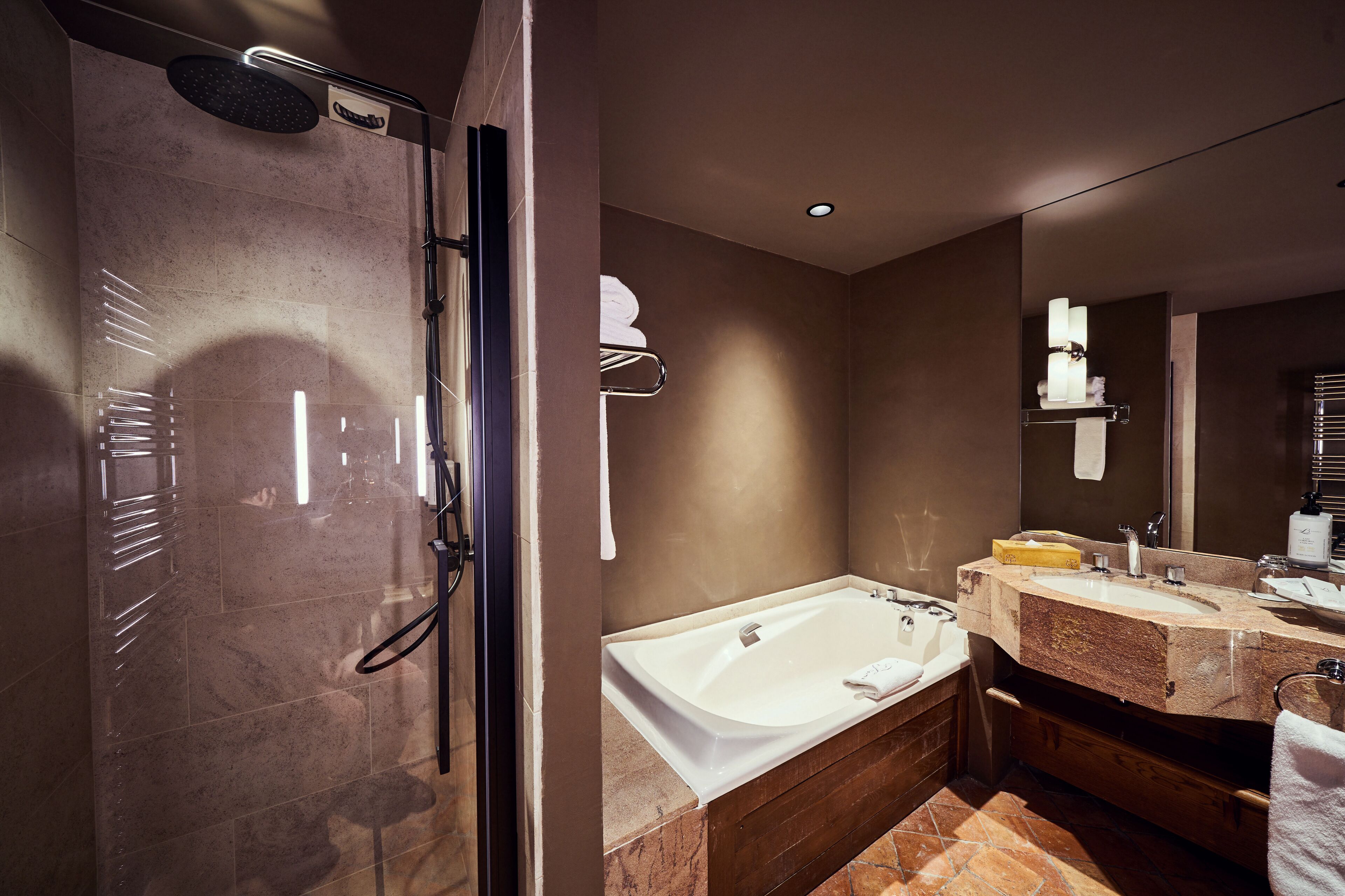 A modern bathroom with a walk-in shower, a standalone bathtub, and a vanity with a mirror.