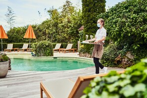 Una piscina al aire libre de temporada, sombrillas
