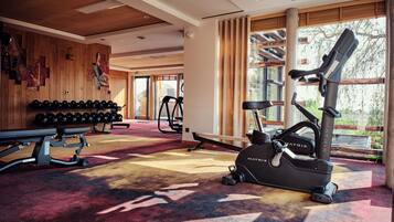Ein Fitnessstudio mit Trainingsgeräten, einer Bank und Hanteln.
