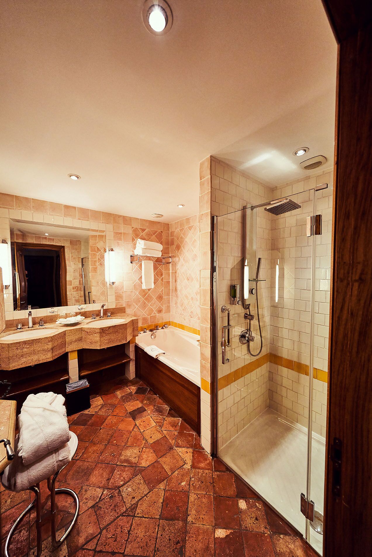 A bathroom with a shower, two sinks, a bathtub, and a mirror.