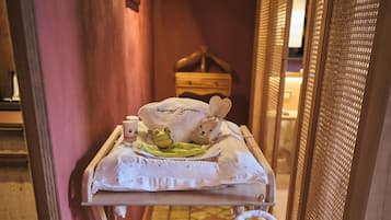 Habitación de hotel con una mesita de madera que sostiene un albornoz, una toalla y un peluche.