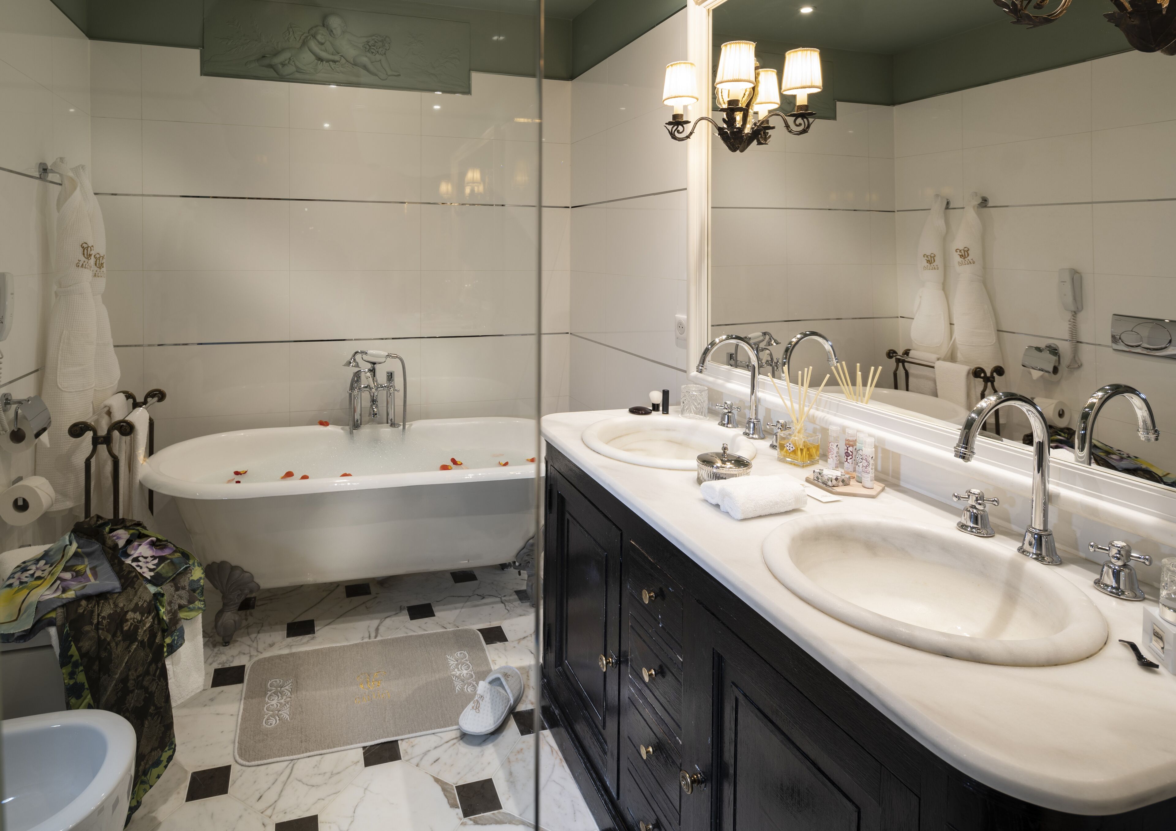 Une salle de bain moderne avec un meuble-lavabo à deux vasques, une baignoire et un grand miroir.
